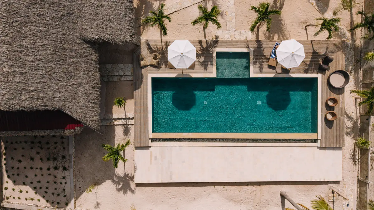 Two white umbrellas beside the pool, from above