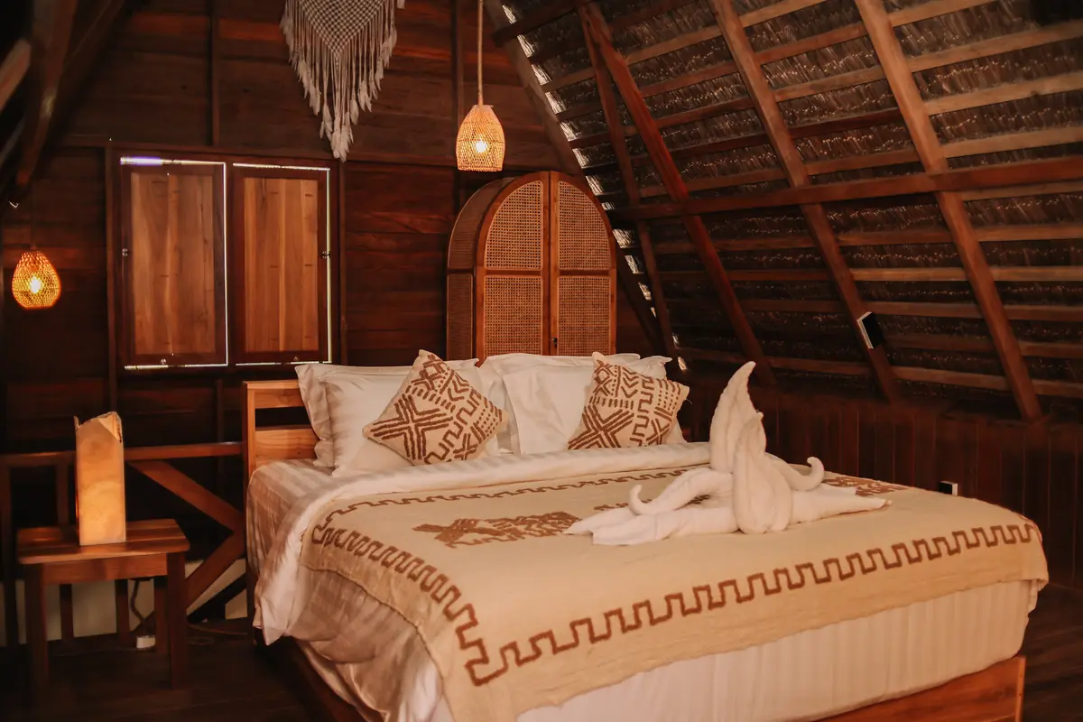 Upper floor of the Family Room with king bed, woven pendant lights and rattan wardrobe