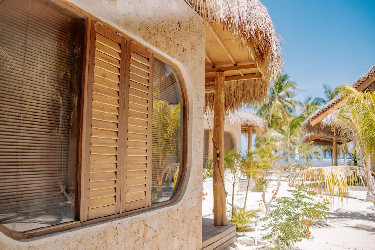 Teak shutters set into a hand-laid limestone wall